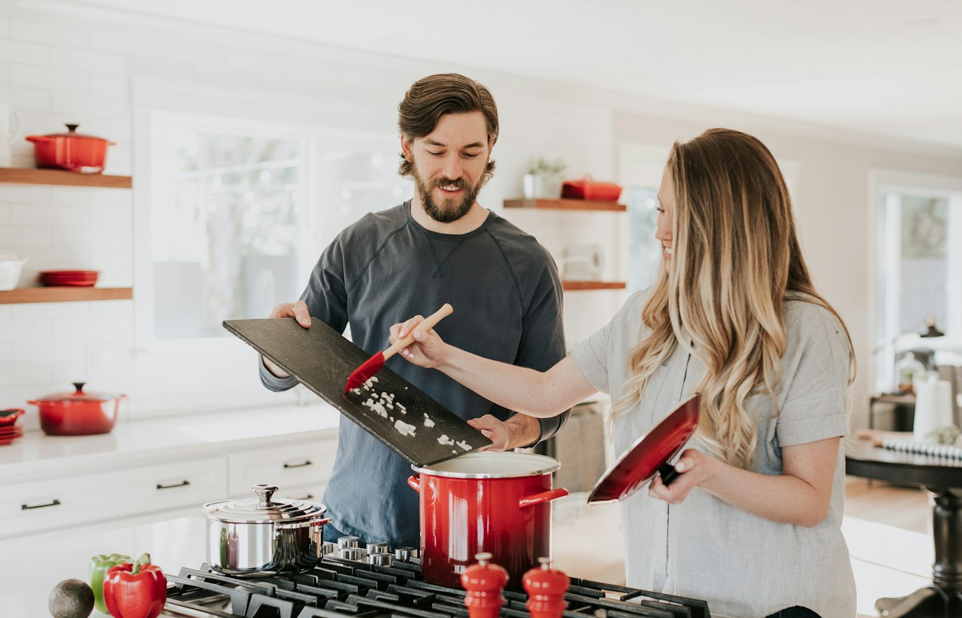 Two people cooking together at a stove in a bright kitchen